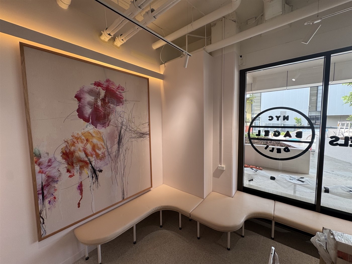 Customer seating area and branded window signage at NYC Bagel Deli