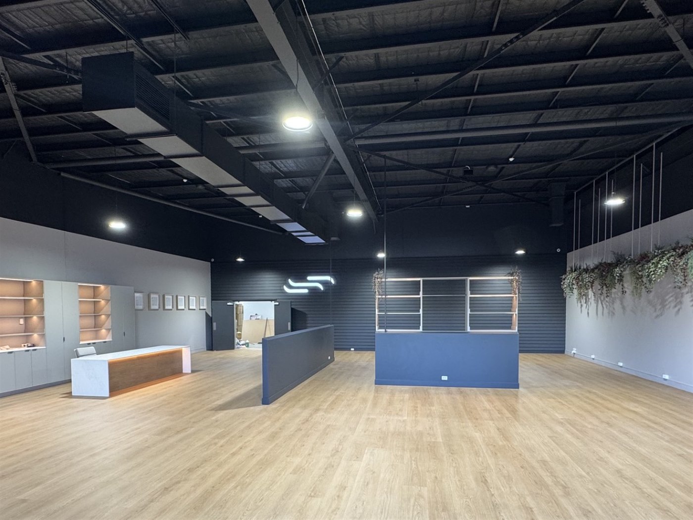 Showroom floor at Sleepy's Brendale with reception counter, display shelving and hanging greenery